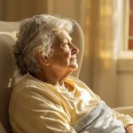 Femme âgée assise dans un fauteuil près d'une fenêtre
